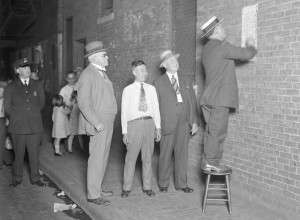 Boston Police in 1930 in Chinatown post a sign in Chinese warning against starting a Tong War. (Boston Public Library Leslie Jones Collection).