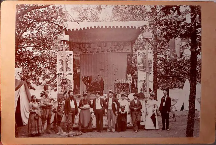 A Kickapoo Medicine Show company in front of a stage.